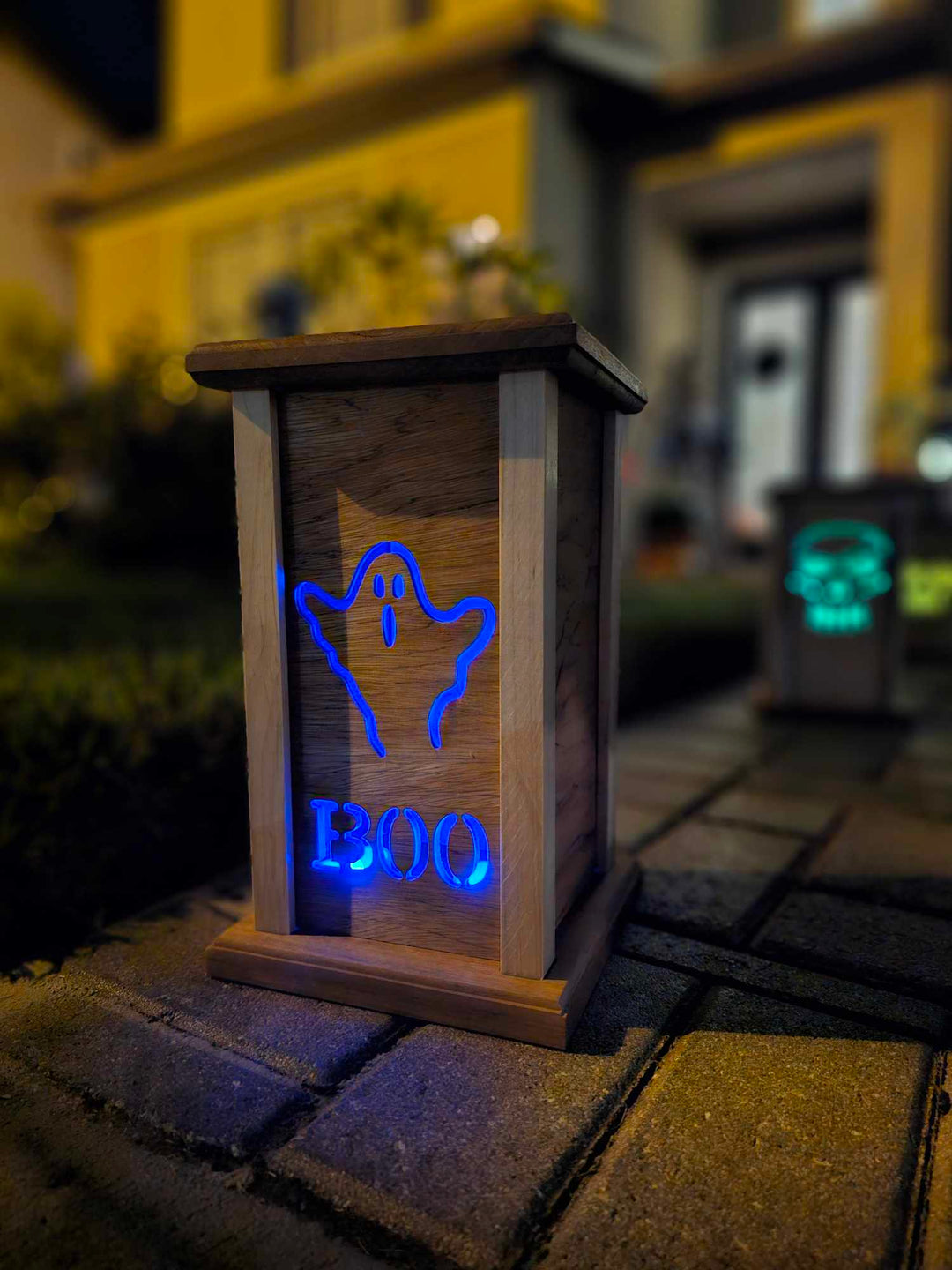 Wooden lantern face with a ghost and the words boo.