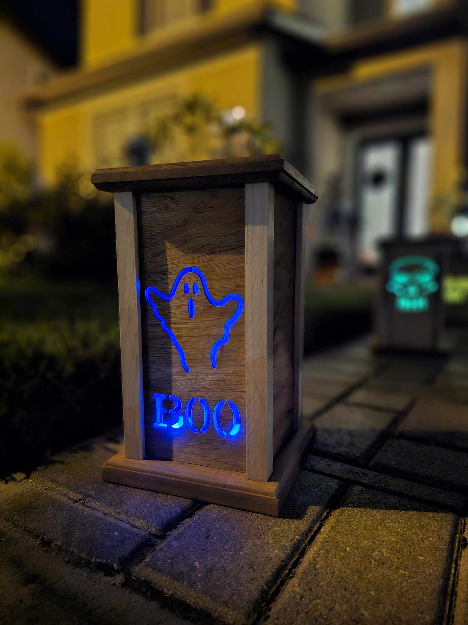 Wooden lantern face with a ghost and the words boo.