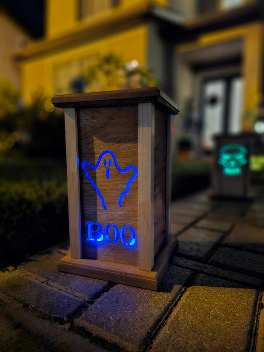 Wooden lantern face with a ghost and the words boo.
