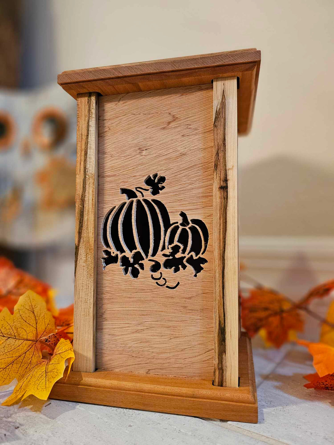 Wooden lantern face showing two pumpkins.