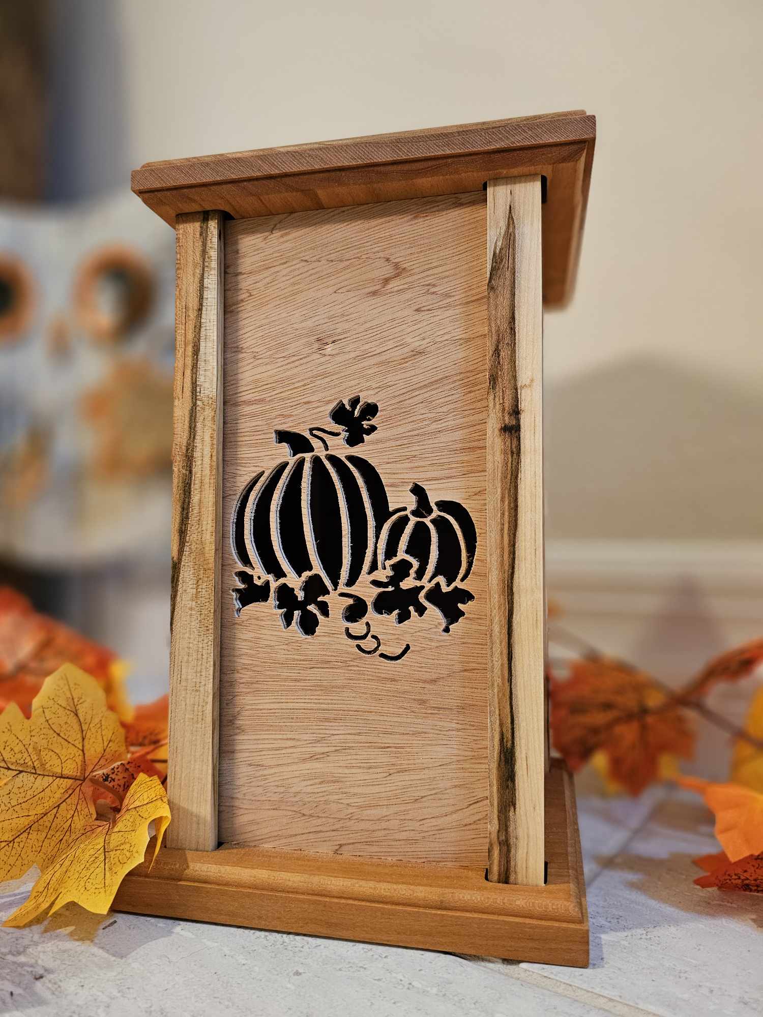 Wooden lantern face showing two pumpkins.