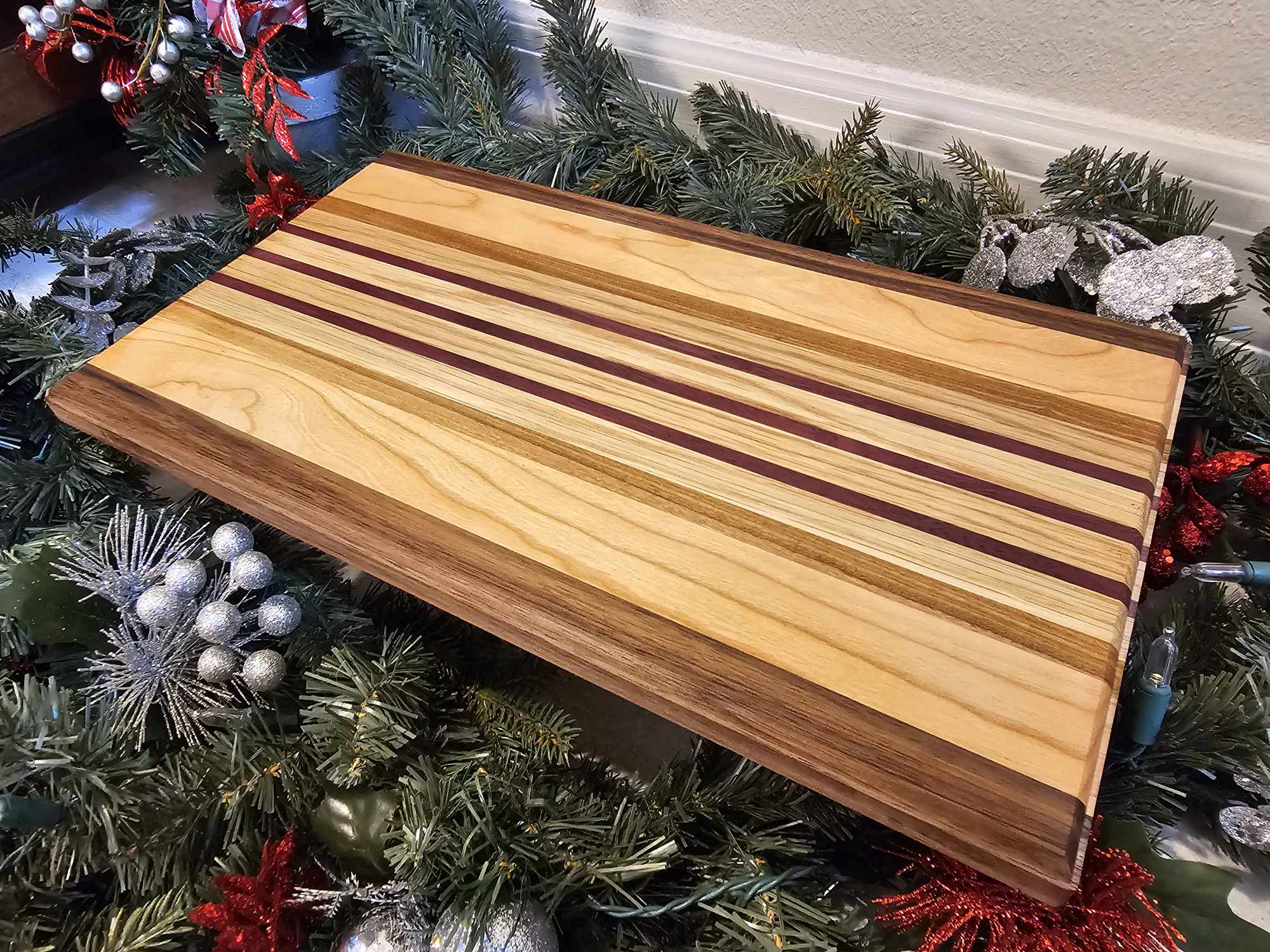 Charcuterie board with strips of walnut, cherry, afromasia, white oak, and purple heart.