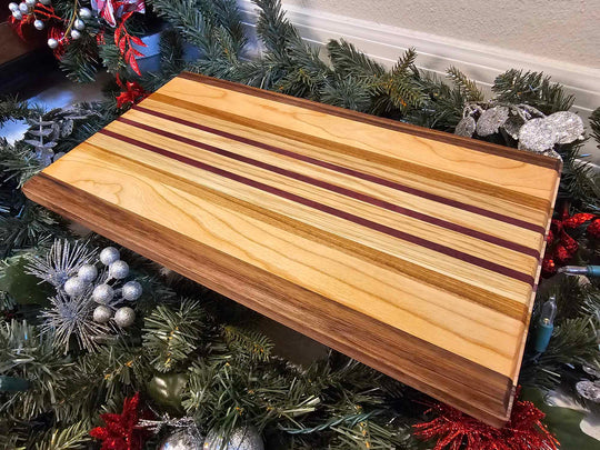 Charcuterie board with strips of walnut, cherry, afromasia, white oak, and purple heart.