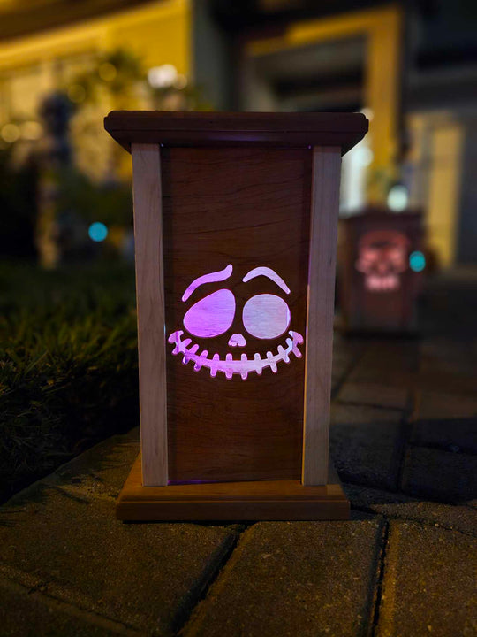 Wooden lantern face with grinning ghost face.