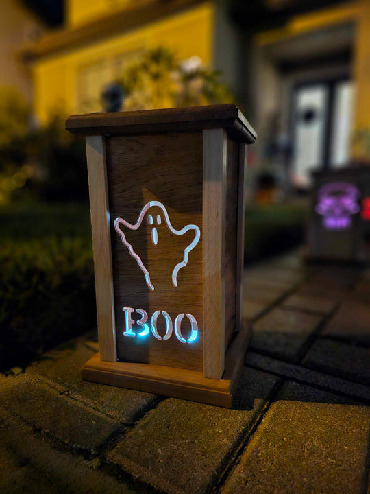 Wooden lantern face with a ghost and the words boo.