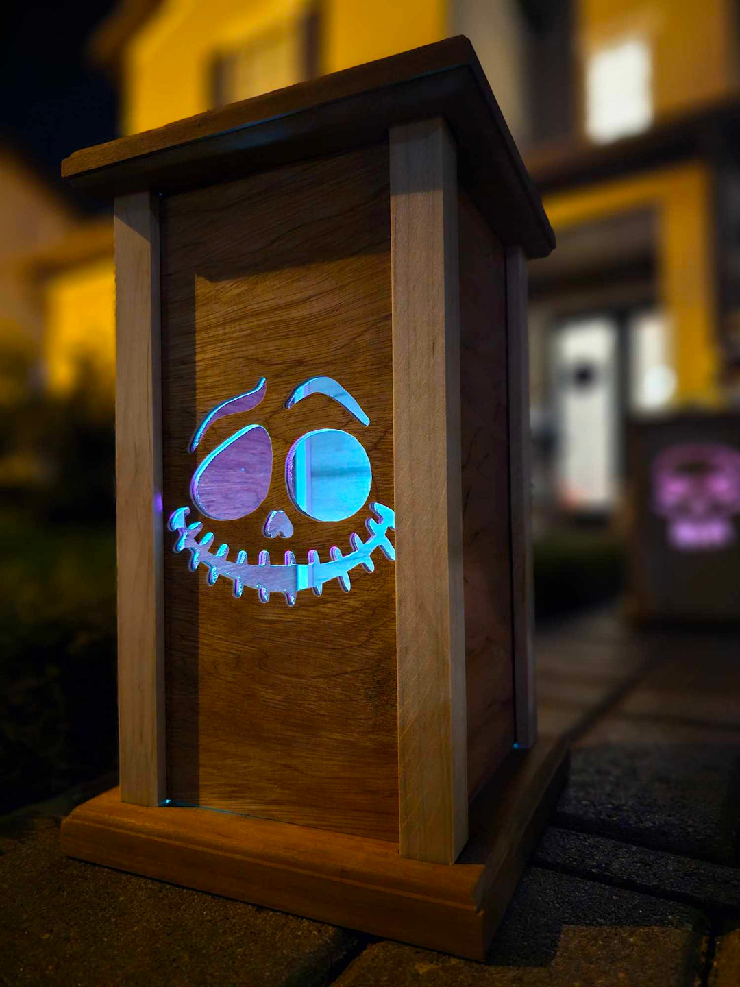 Wooden lantern face with grinning ghost face.