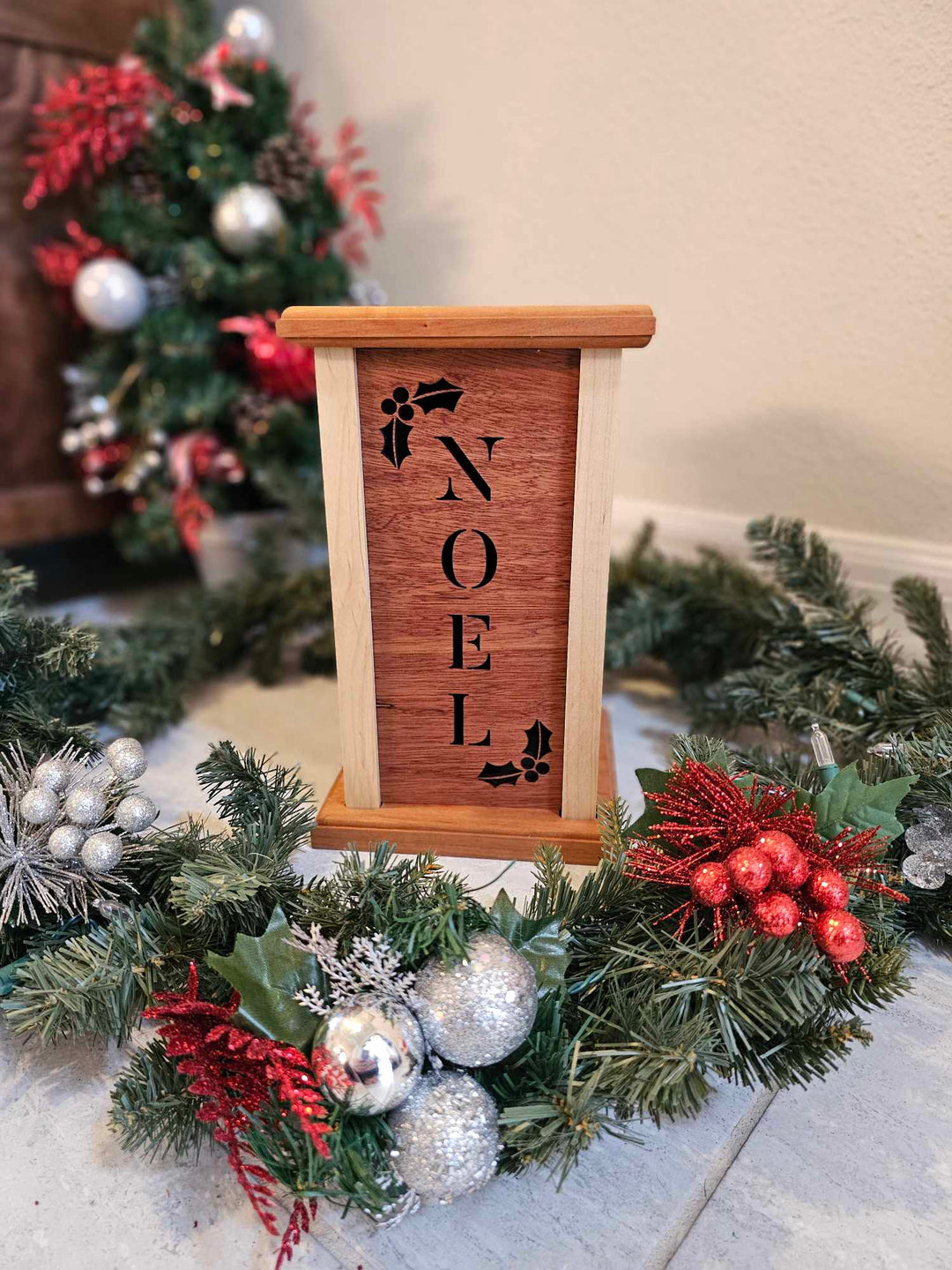 Wooden Lantern face with holly and the word Noel.