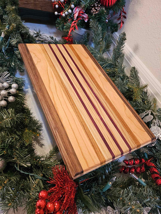 Charcuterie board with strips of walnut, cherry, afromasia, white oak, and purple heart.