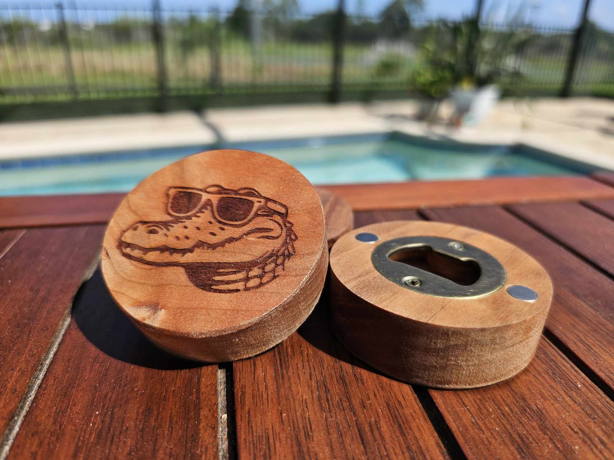 Wooden puck-style bottle opener depicting a crocodile wearing sunglasses.