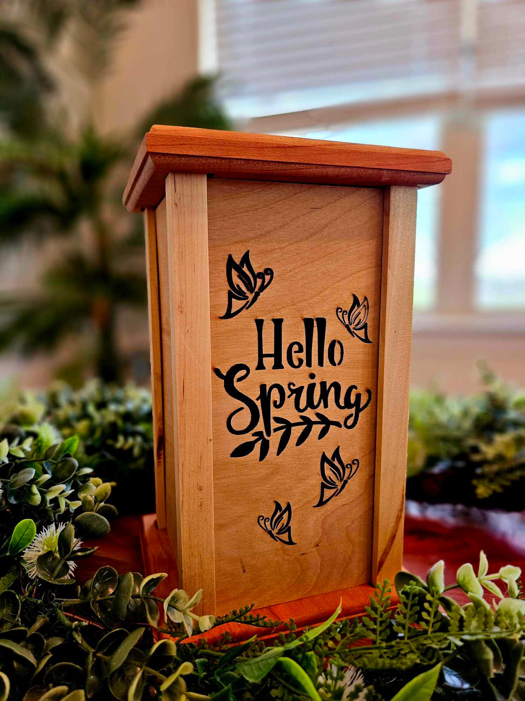 Wooden lantern face with butterflies and the words Hello Spring.