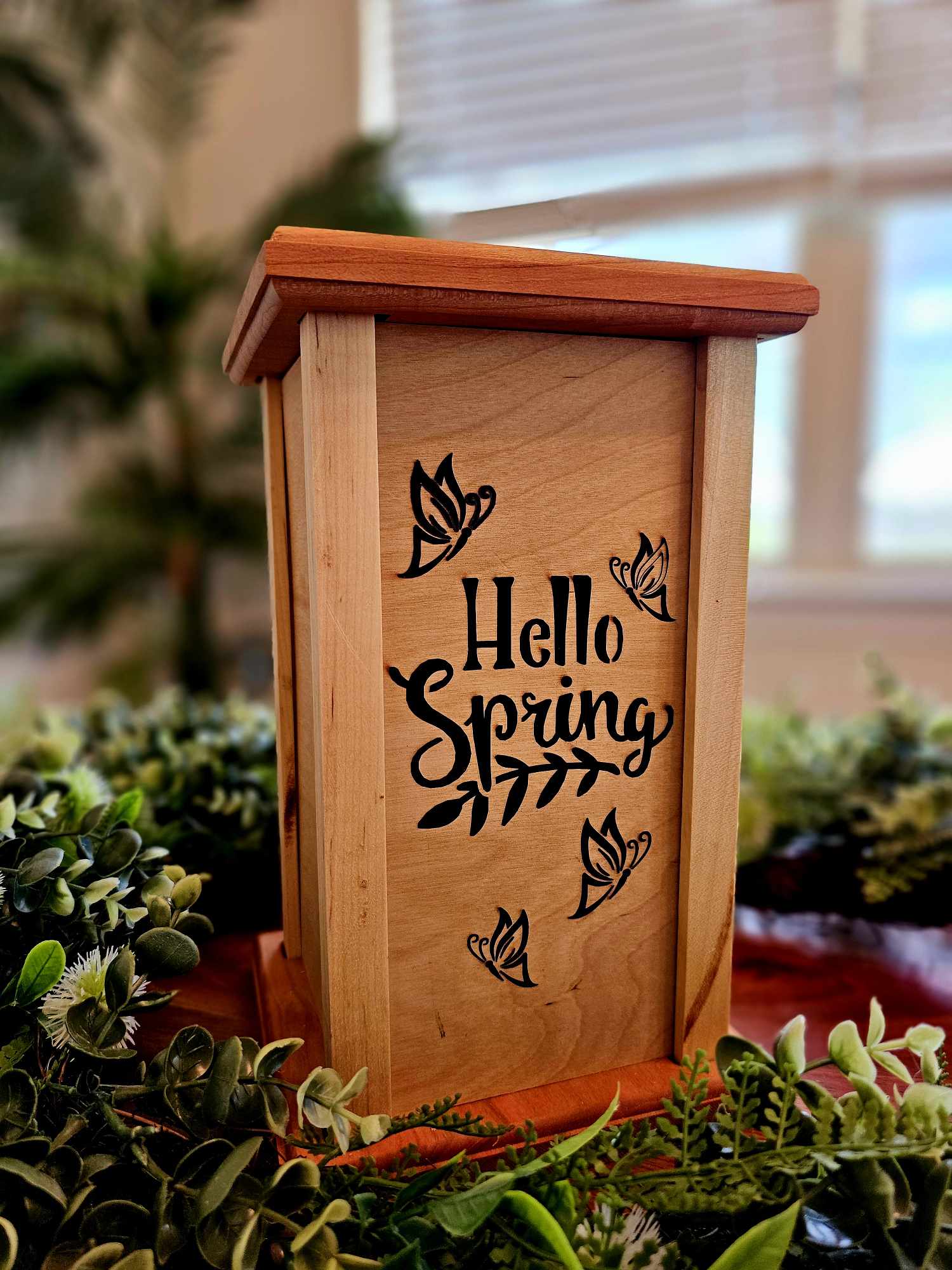 Wooden lantern face with butterflies and the words Hello Spring.