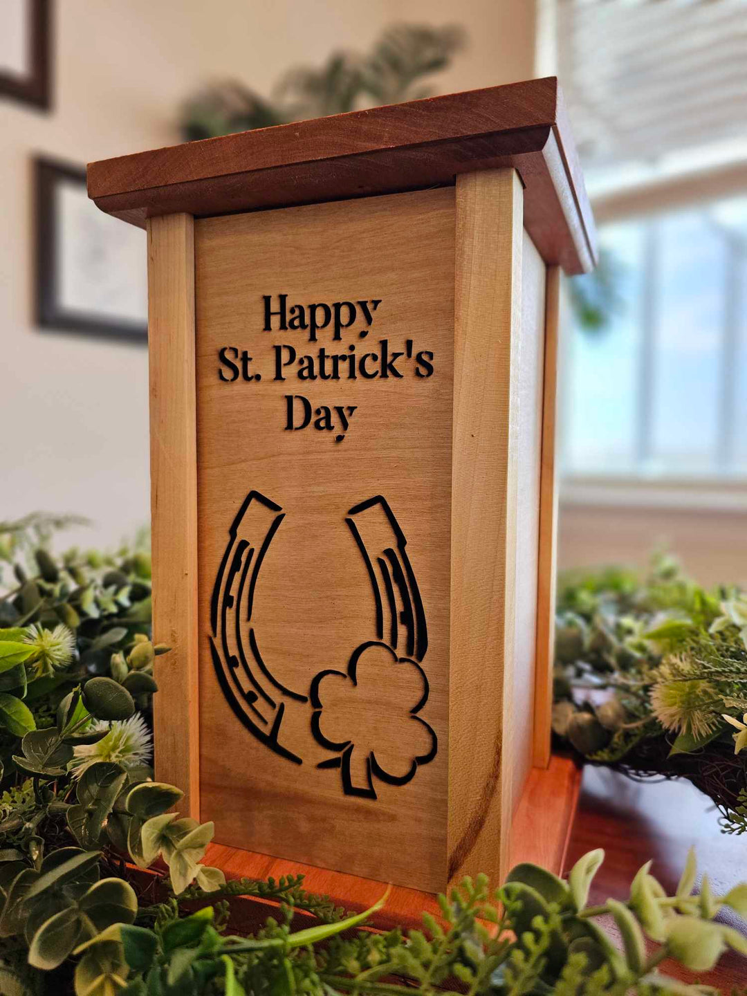 Wooden lantern face depicting a horseshoe and three leaf clover with the words Happy St. Patrick's Day.
