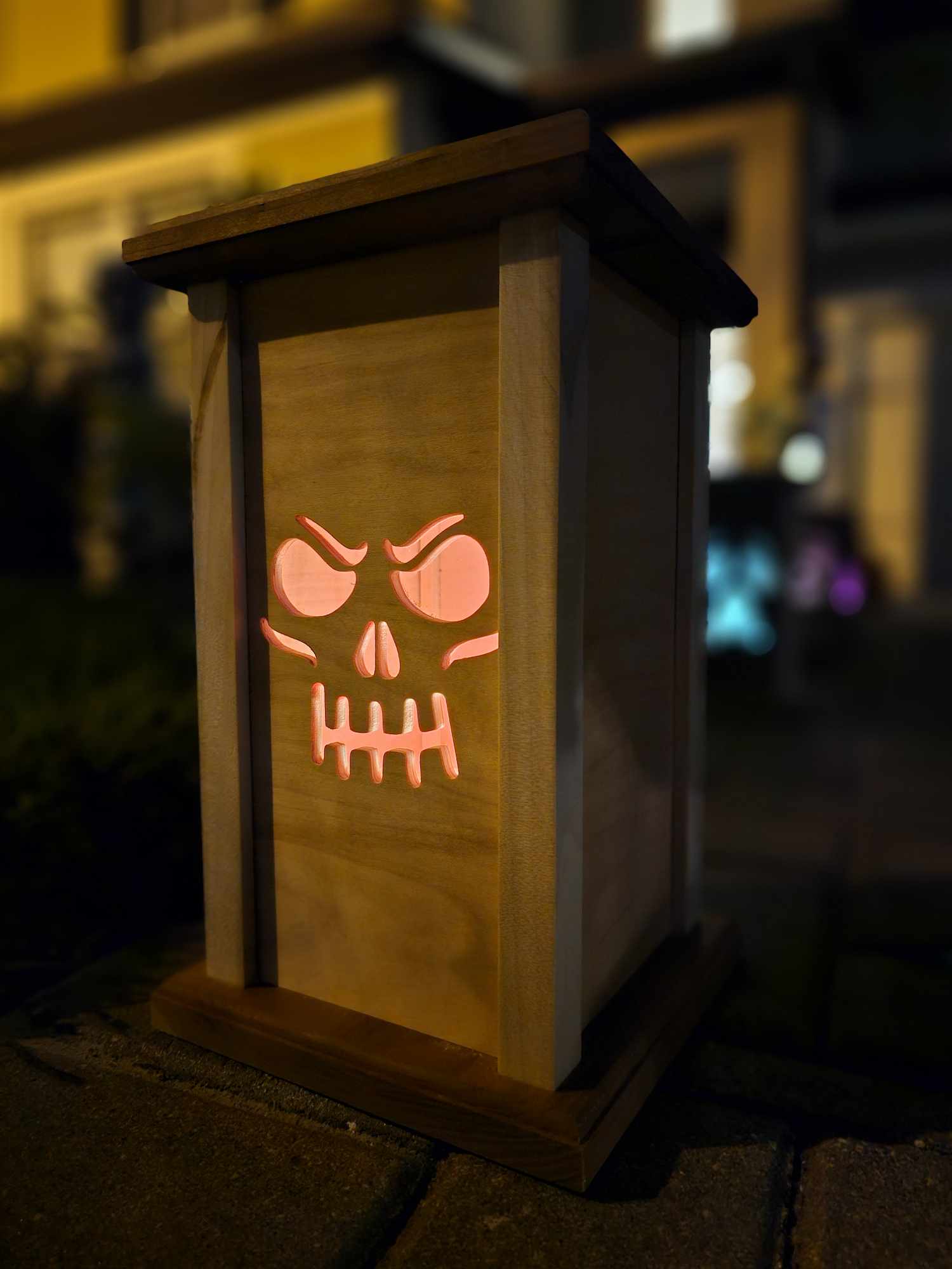 Wooden Lantern face depicting a grinning skull face.