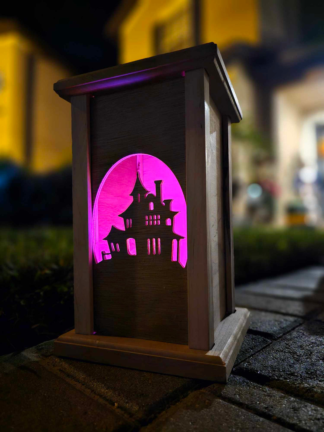 Wooden lantern face depicting a haunted house.