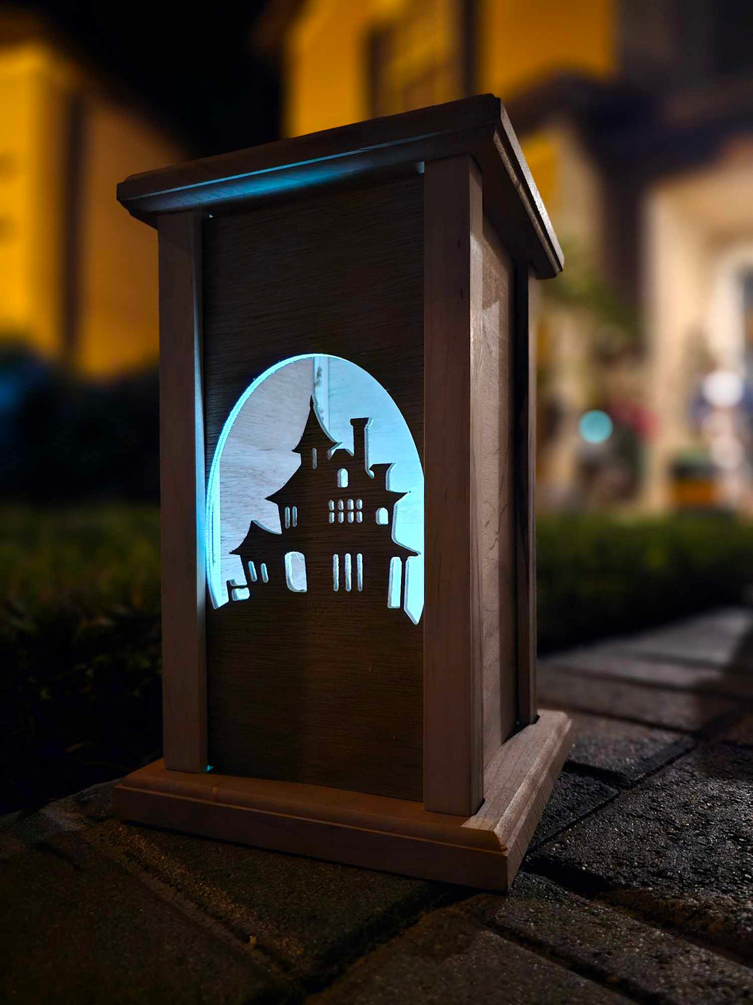 Wooden lantern face depicting a haunted house.