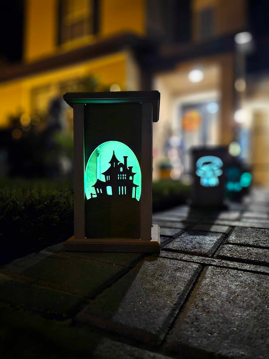 Wooden lantern face depicting a haunted house.