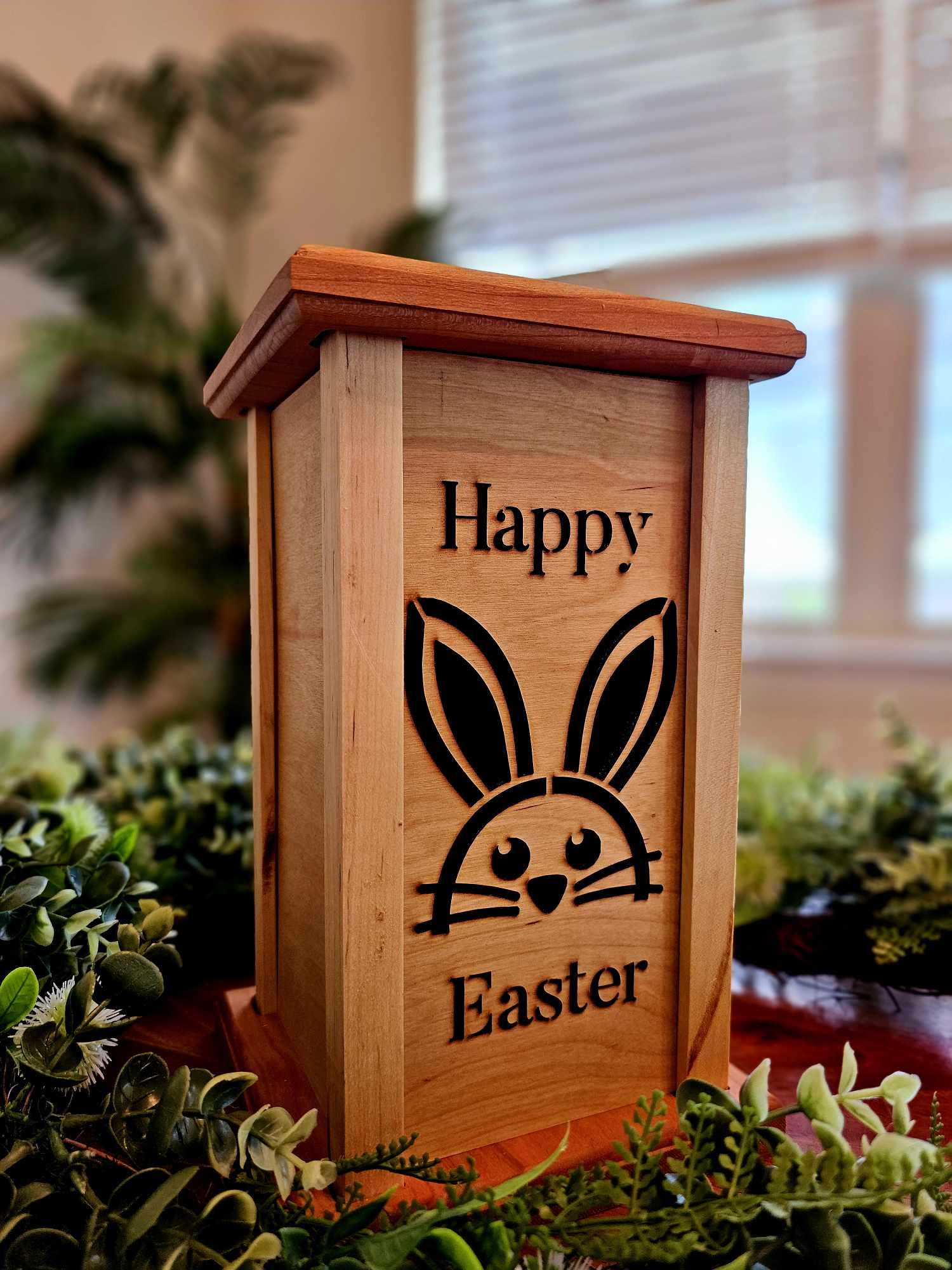 Wooden lantern face showing a bunny with the words Happy Easter.